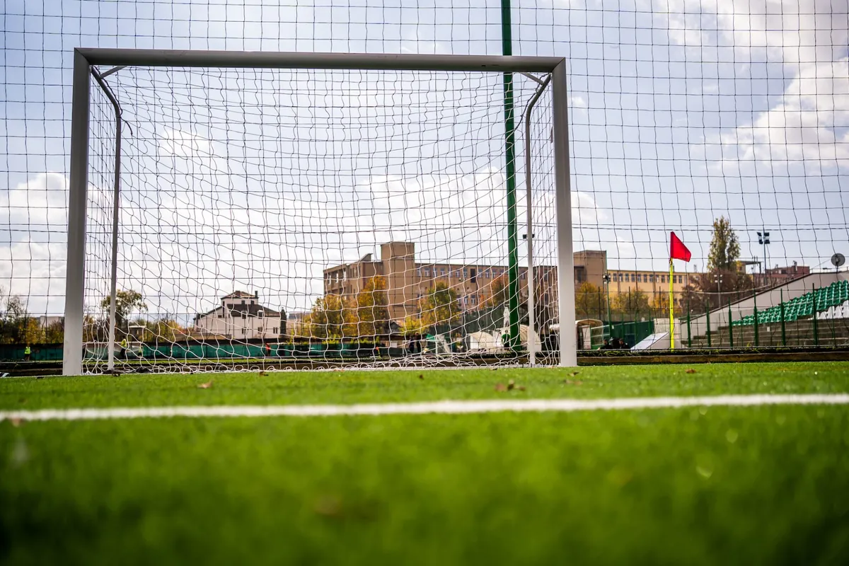 Manjši gol z belo mrežo na umetni travi športnega igrišča