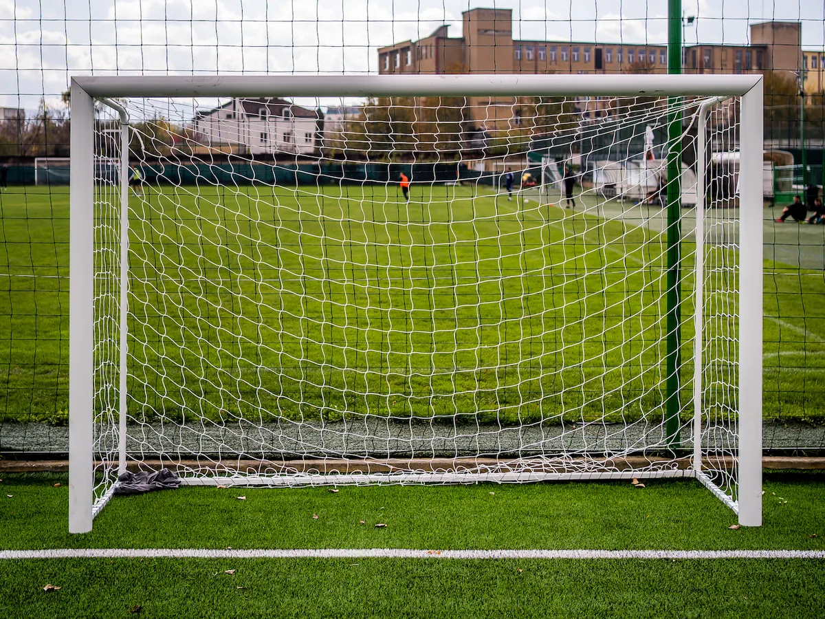 Mali nogometni gol z belo mrežo na umetni travi