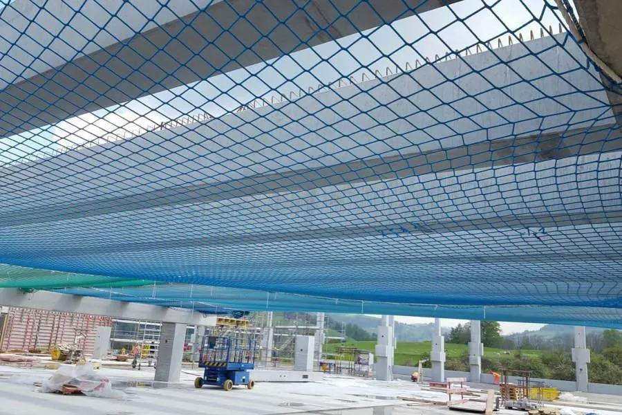 Modra varnostna lovilna mreža, napeta pod betonsko ploščo gradbišča